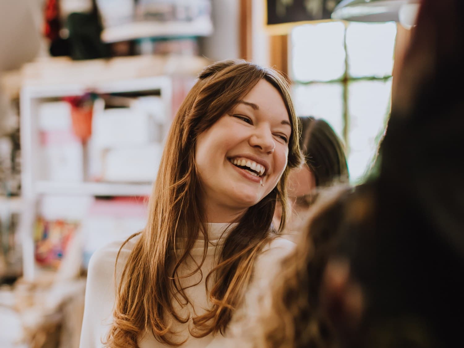 A bride laughing while getting ready